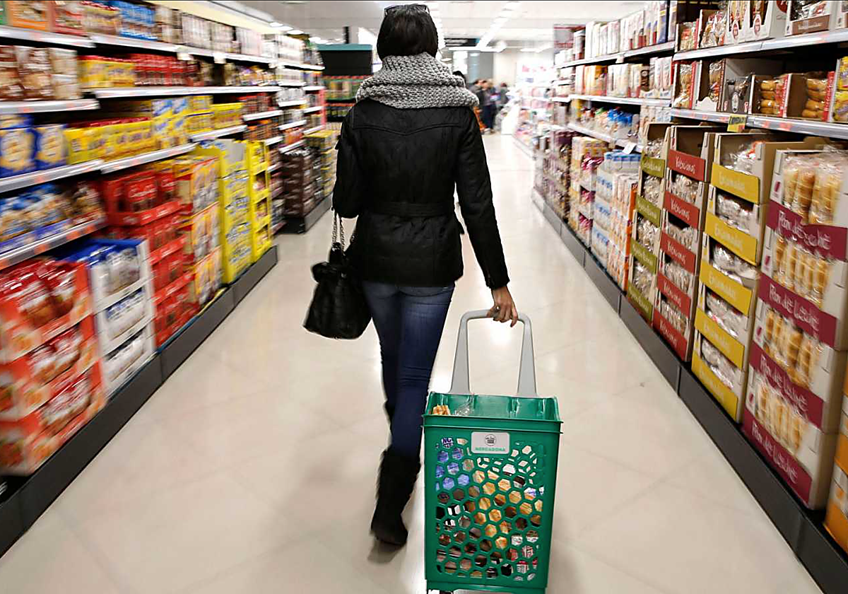 Una clienta hace la compra en un supermercado en foto de archivo