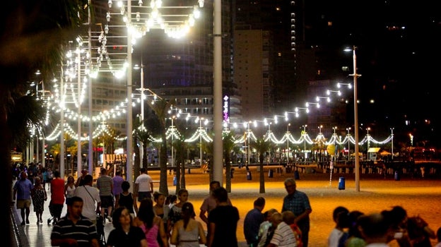 Iluminación nocturna en el paseo de la playa de Benidorm difundida por la compañía de reserva de apartamentos RentBenidorm.