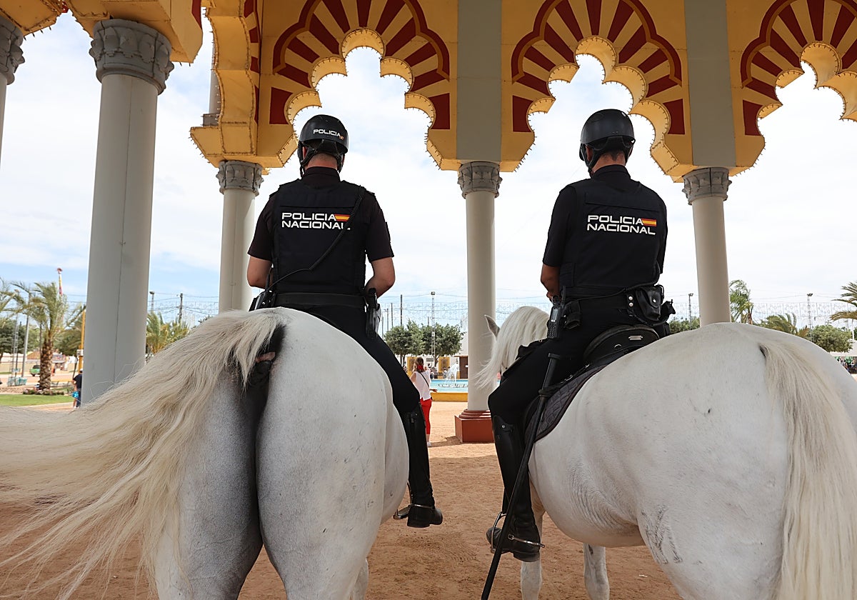 Dos agentes de la Policía Nacional a caballo en la portada de la Feria de Córdoba