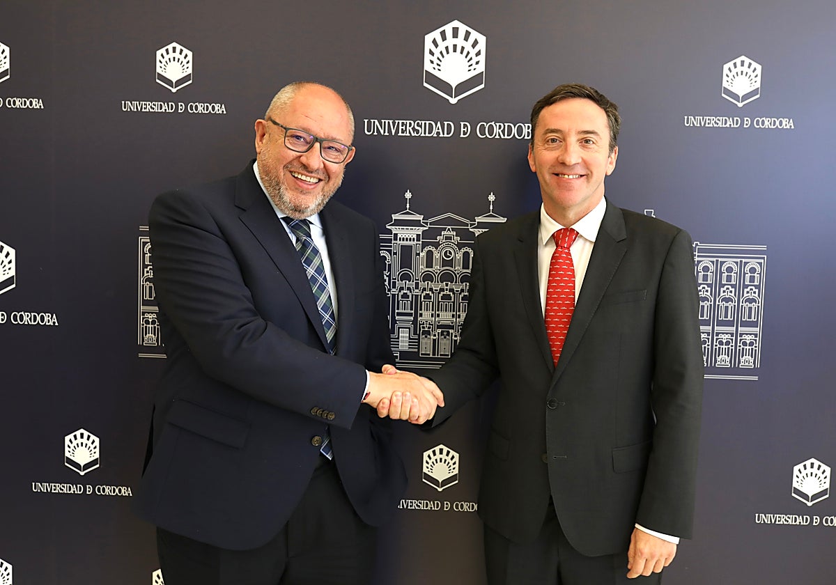 Manuel Torralbo, rector de la UCO, estrecha su mano con Ricardo Domínguez (derecha)