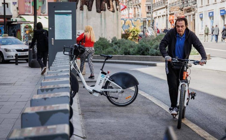 Imagen principal - En la imagen principal, la estación de Bicimad de la plazuela de Antón Martín, este lunes, prácticamente vacía. Debajo, un operario recoge una de las bicis abandonadas. En la última foto, un joven hace un caballito, en el barrio de Simancas. 