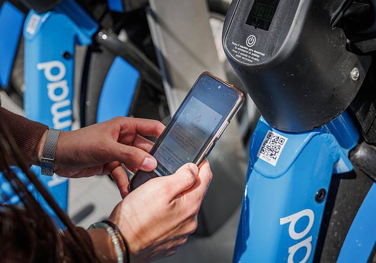 Una usuaria se da de alta en Bicimad, junto a una de las estaciones de la red