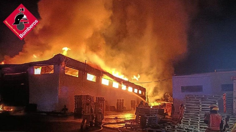 La columna de fuego del incendio de una fábrica de palets visible a varios kilómetros desde la AP-7 en Elche