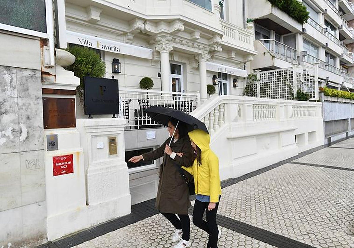 Una mujer y una niña pasean por delante del restaurante donostiarra al que un juez ha dado la razón tras penalizar a un cliente que no avisó una cancelación