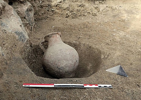 Imagen secundaria 1 - Vista general de un yacimiento prehistórico, junto a un jarro tardorromano y restos óseos de un individuo de la época prehistórica