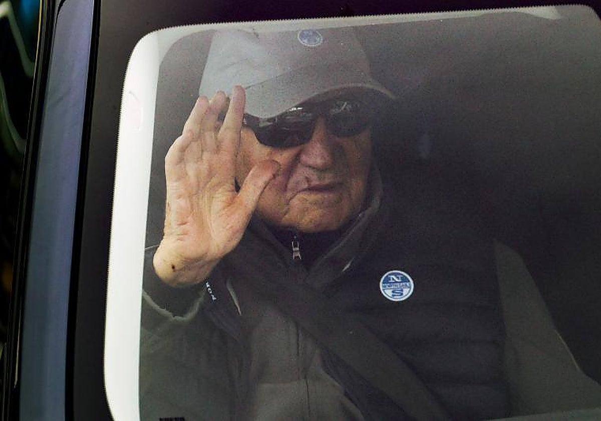 Don Juan Carlos saluda a la prensa desde el coche de su amigo Pedro Campos, este domingo en Sangenjo