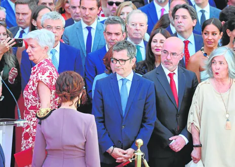 Imagen secundaria 1 - 4. Cuando intentó acceder a la tribuna de autoridades, la jefa de protocolo de la Comunidad cortó el paso al ministro, pese a su insistencia // 5. El ministro tuvo que presenciar la parada cívico-militar fuera de la tribuna. Al cruzarse después Ayuso, la frialdad se intuyó con claridad // 6. La ministra de Defensa participó en la ofrenda floral. Bolaños, no. Ambos, junto al diputado regional José Cepeda, al marcharse de Sol.