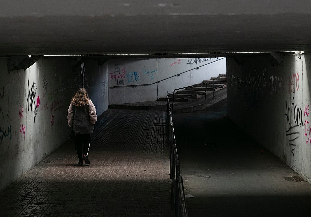 Una persona pasa por el túnel de la barriada periférica