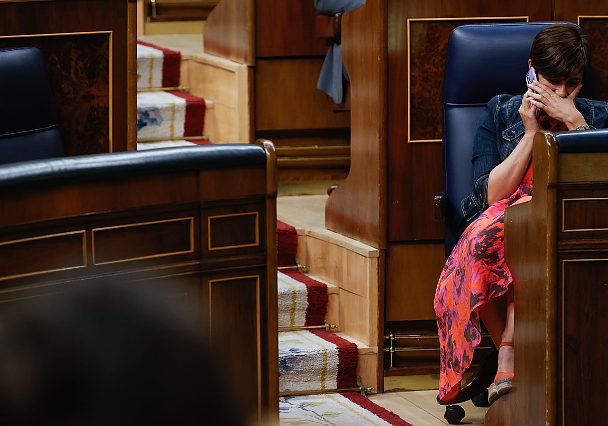 La portavoz del Gobierno, Isabel Rodríguez, se tapa la mano para hablar por teléfono, durante el pleno parlamentario de este miércoles