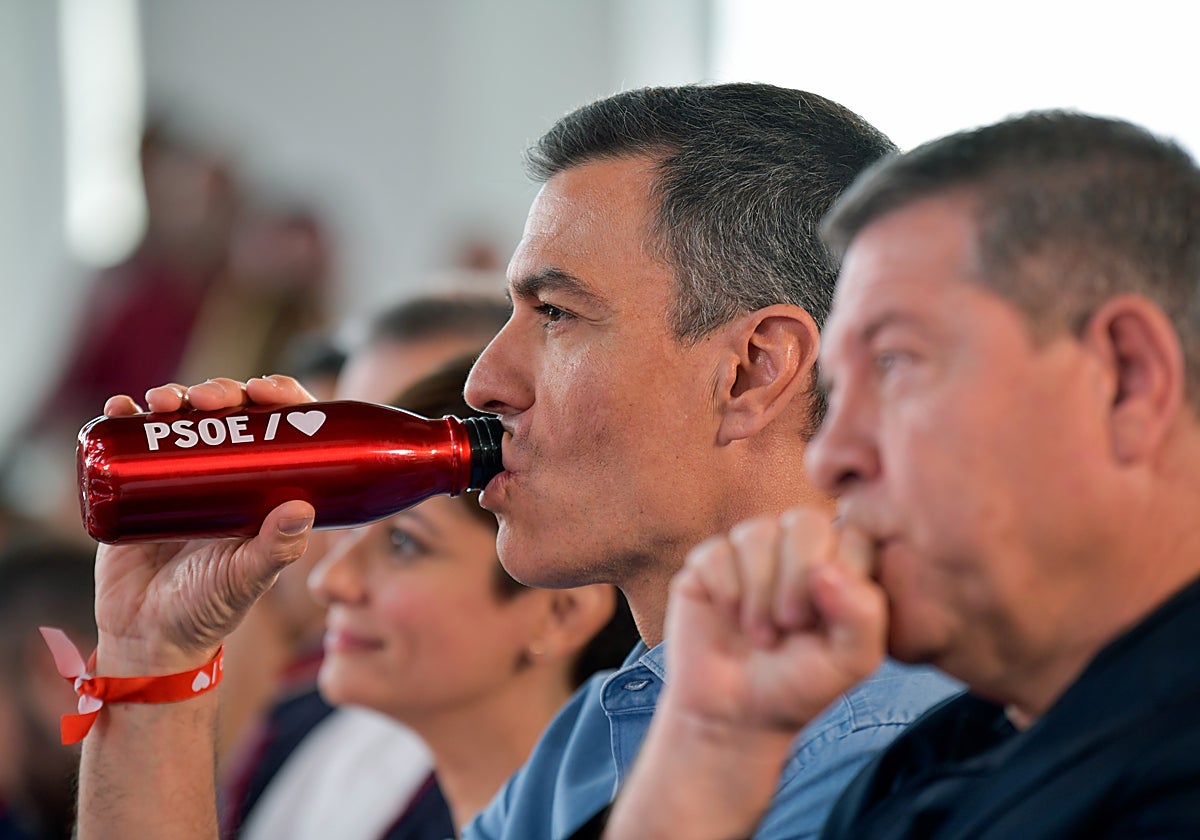 Sánchez, bebiendo agua, y en primer plano Page, durante el mitin del PSOE este domingo en Puertollano (Ciudad Real)