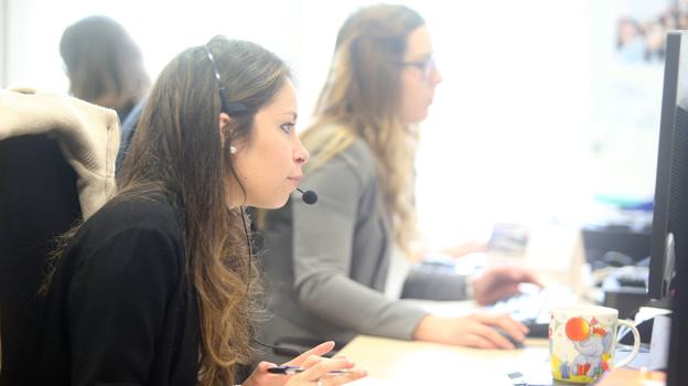 Dos jóvenes, trabajando en un centro de atención a clientes