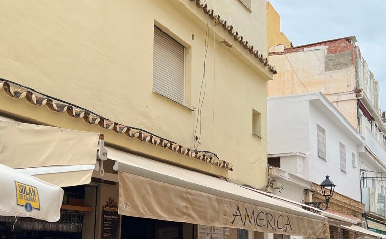 Imagen principal - Paula pidió ayuda por la ventana encima del bar América (foto 1), donde estaba Víctor Pérez (foto 2) que trató de socorrerla hasta subiendo con una escalera. No pudo. Tuvo que contar a su esposa, Victoria Molina, que su amiga había sido asesinada en la comercial calle San Ginés (foto 3) de la Carihuela de Torremolinos.