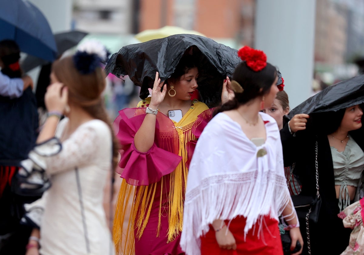 Chicas vestidas de gitana se protegen contra la lluvia