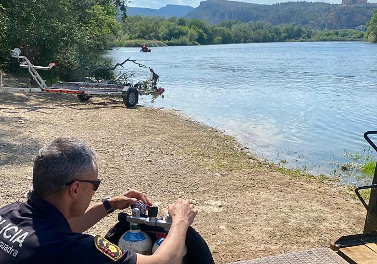 Uno de los agentes durante el dispositivo tras localizar el cadáver en un coche hundido en el Ebro