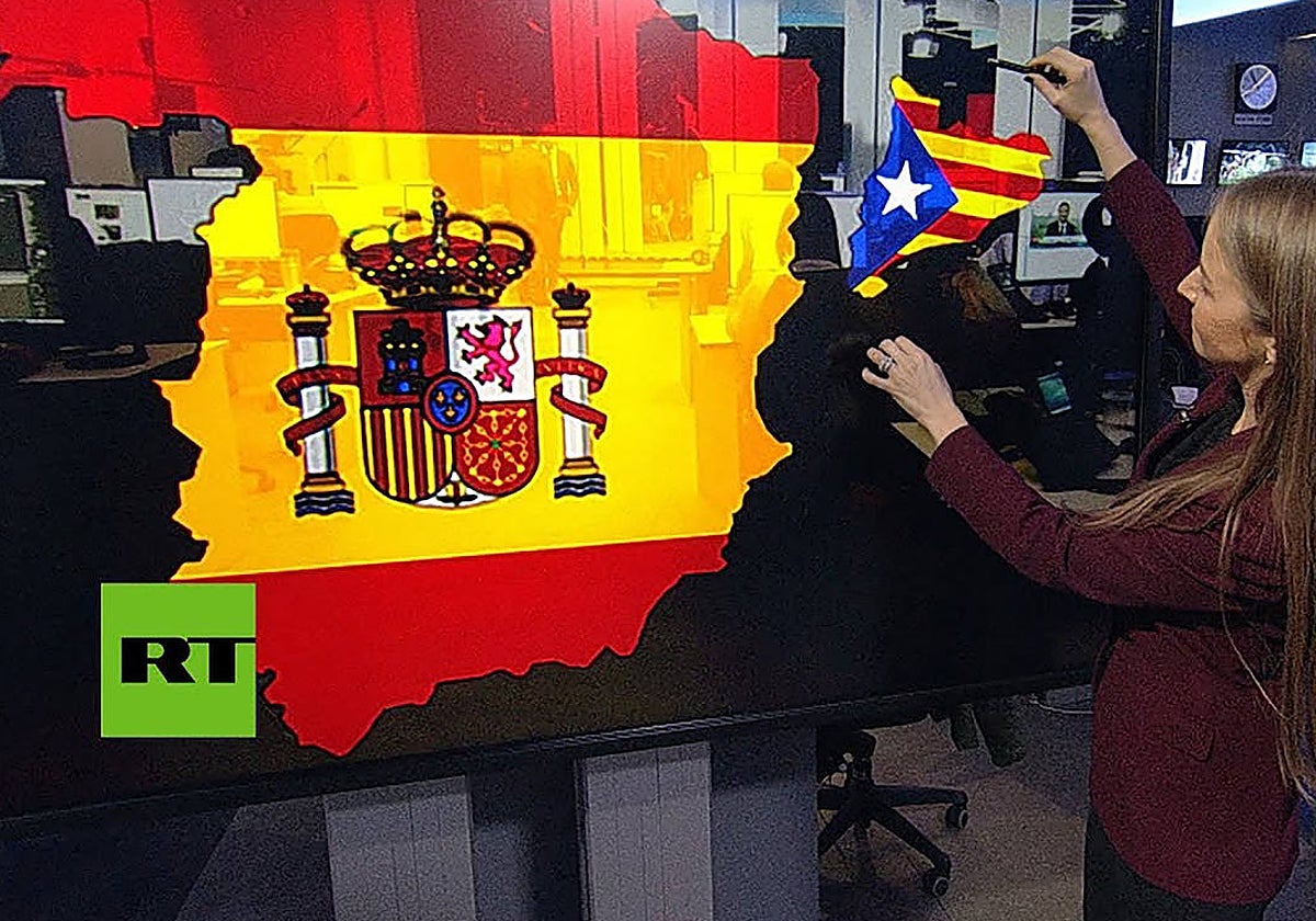 Una presentadora del canal estatal RussiaToday (RT) muestra un mapa de España del que se desgaja Cataluña