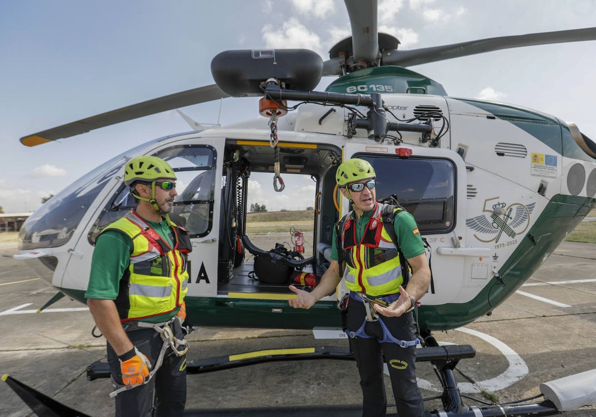 Los guardias Juan Cruz (izquierda) y Francisco Javier Martínez junto al helicóptero con el que trabajan esta romería