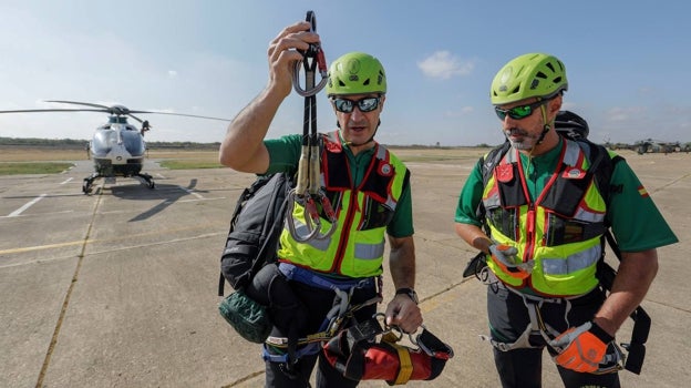 Los dos agentes muestran el material que utilizan para descolgarse en el aire