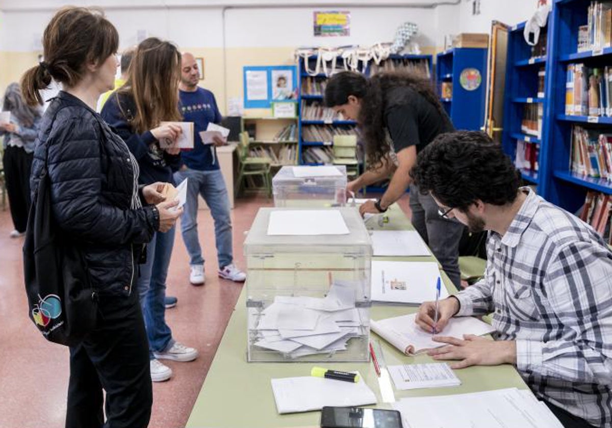 Varios miembros de una mesa electoral se emplean a fondo durante el inicio de las votaciones