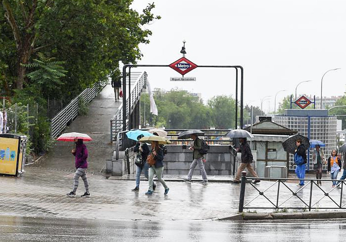 Varias personas caminan bajo la lluvia