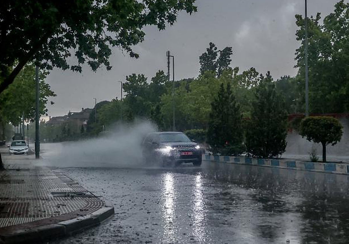 Un coche circula bajo la intensa lluvia en la capital