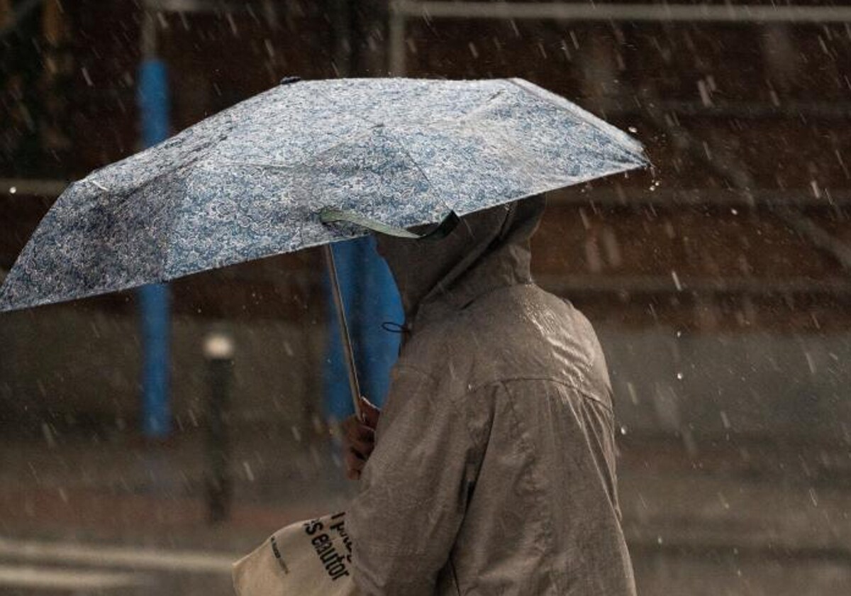 Una mujer con paraguas bajo la lluvia, en una tormenta reciente en Madrid