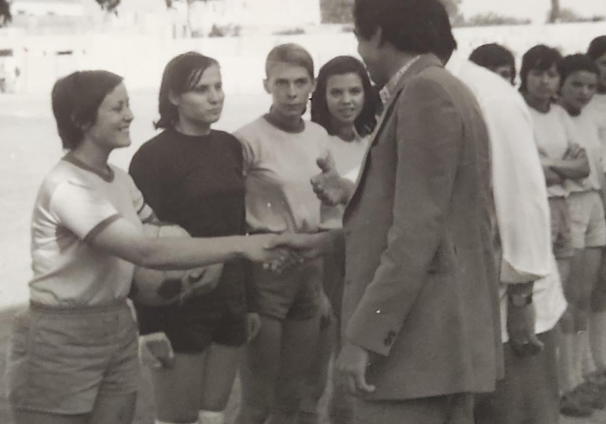 La cordobesa Isi sostiene el balón y estrecha la mano del organizador antes de un partido de fútbol en Marruecos