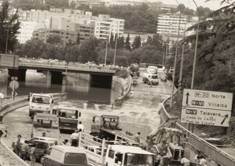 Imagen secundaria 1 - Arriba, operarios achicando agua en el Estadio Santiago Bernabéu, donde se inundaron hasta los vestuarios. Abajo, izq., estado en que quedó la M-30 al día siguiente de las tormentas. Dcha, la grúa se lleva uno de los vehículos afectados por la inundación. 