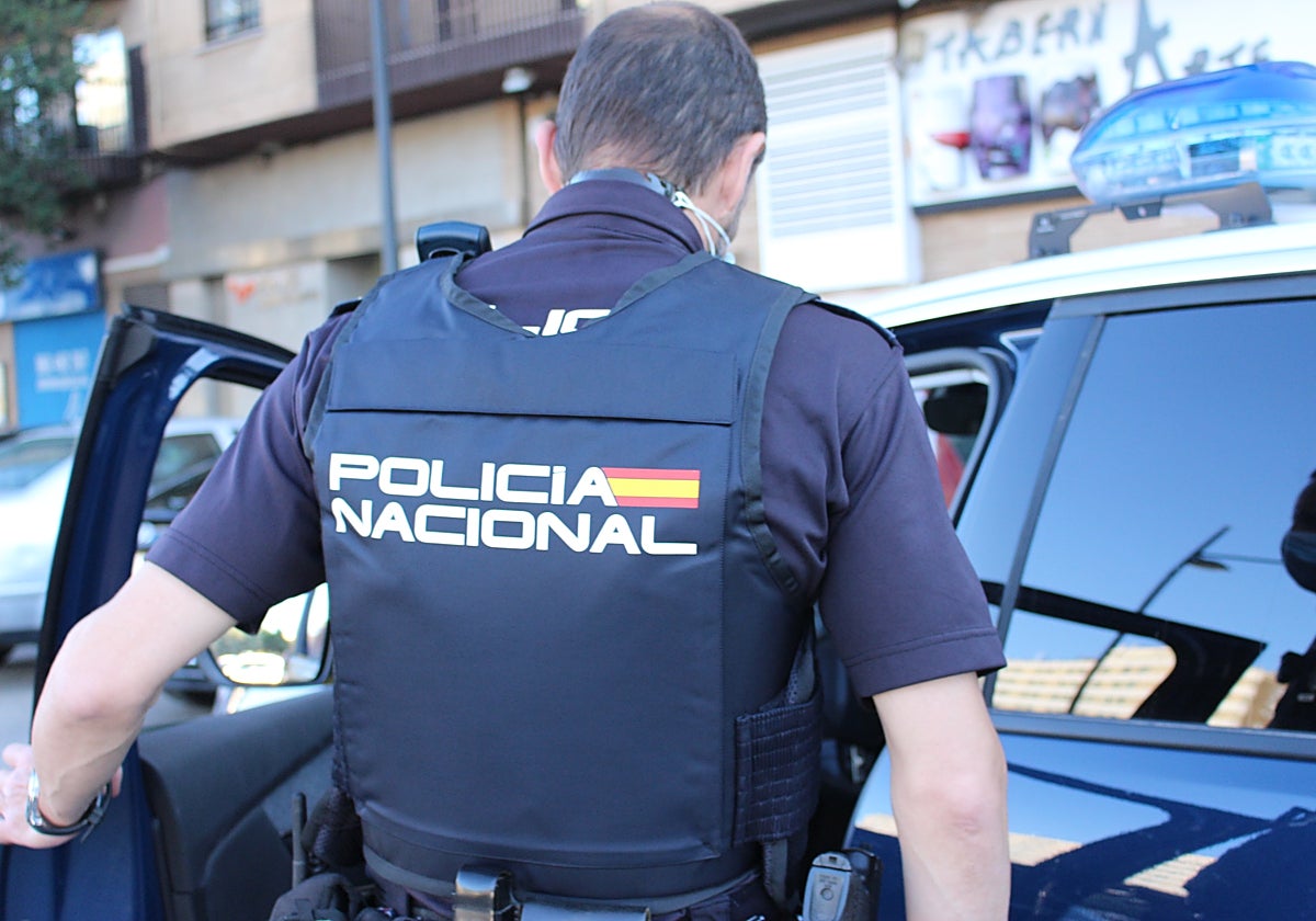Un policía nacional sube a un coche patrulla en Valencia
