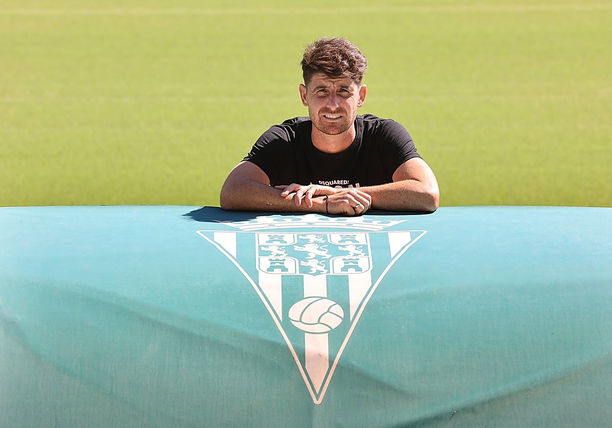 El capitán del Córdoba CF, Javi Flores, junto a un escudo en el estadio El Arcángel