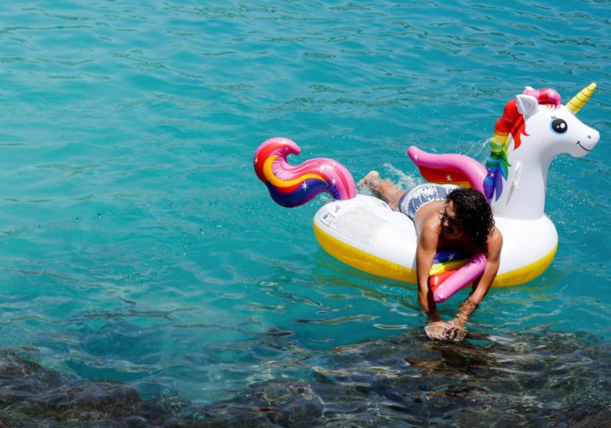 Una bañista se refresca del calor con una colchoneta en una playa de Gran Canaria