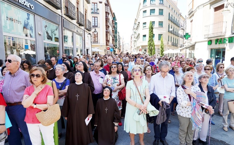 Imagen principal - Arriba, fieles durante la celebración; sobre estas líneas, momento en el que la Policía pide a uno de los asistentes que se identifique; a la derecha, el arzobispo en la torre de la Catedral