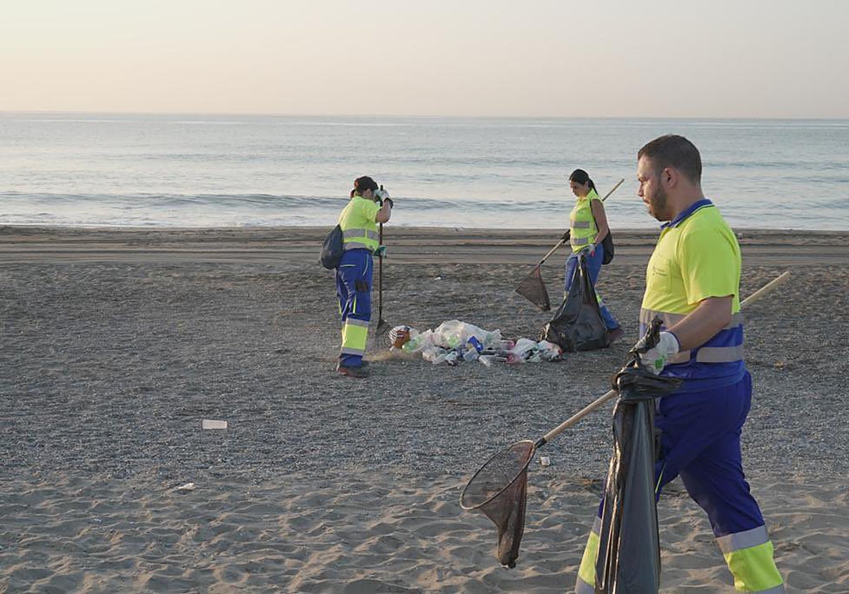 Operarios recogiendo la basura de las playas tras la celebración de San Juan