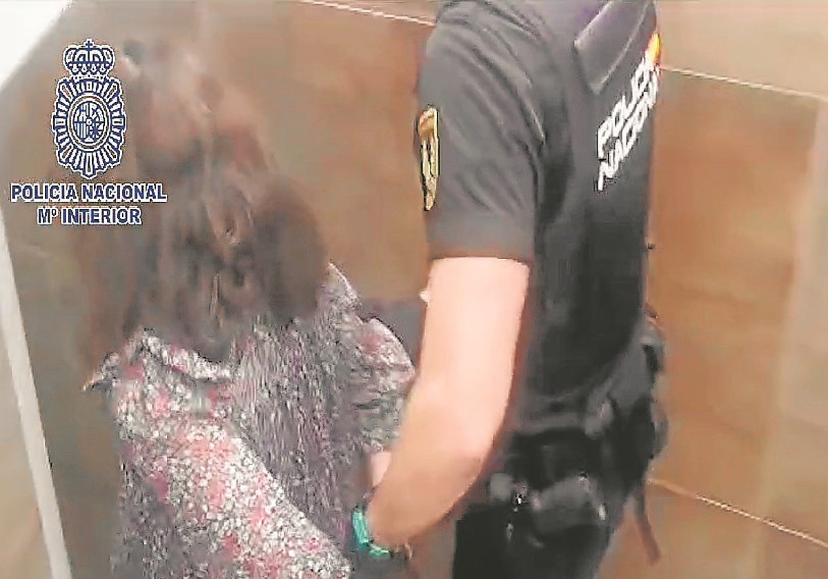 Un agente traslada a la detenida, acusada de diez estafas