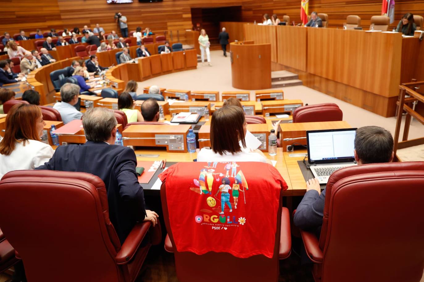 La procuradora socialista Laura Pelegrina coloca una camiseta del Orgullo sobre su asiento durante la segunda sesión del pleno de las Cortes de Castilla y León