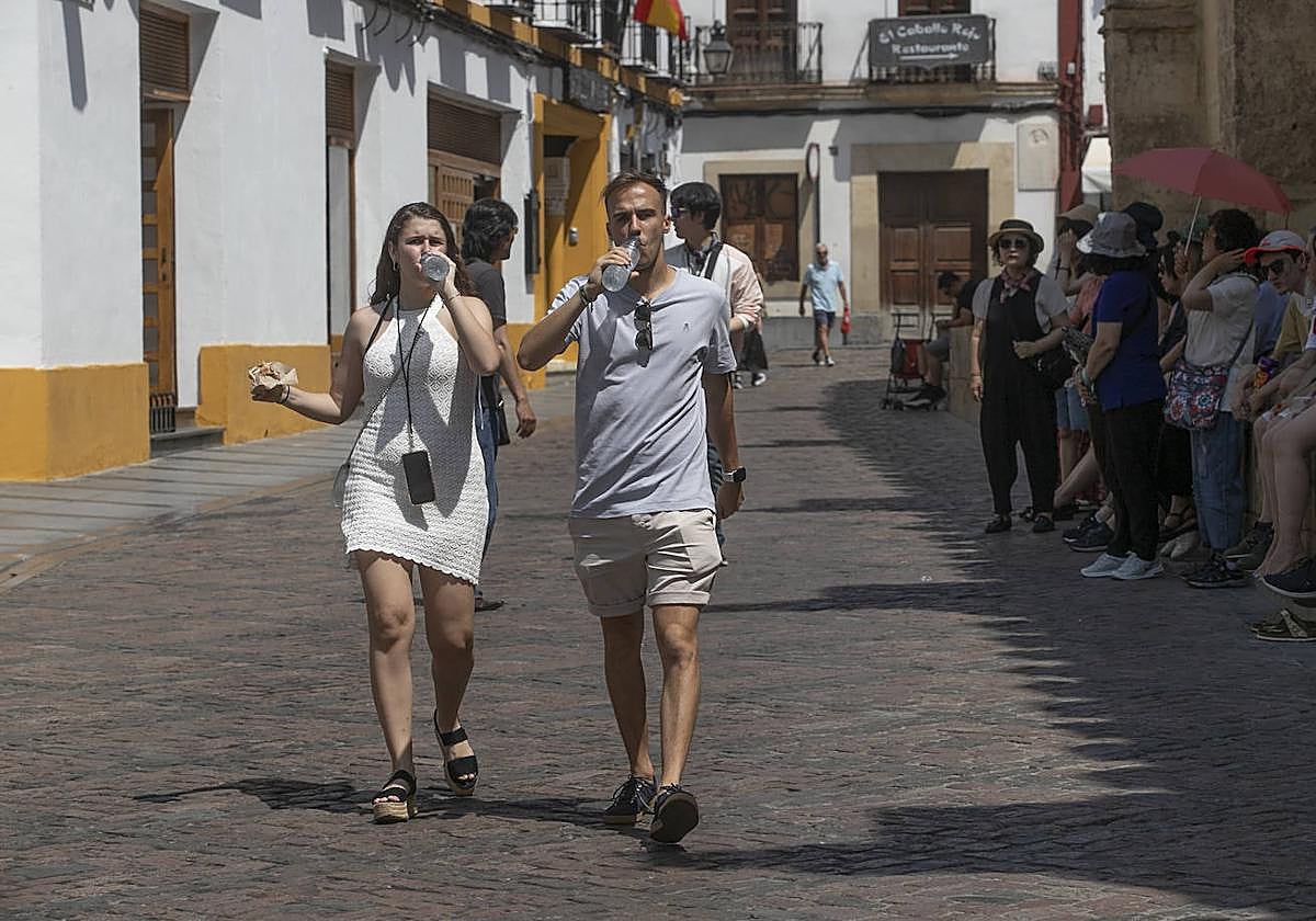 Una pareja de turistas se refresca en el entorno de la Mezquita-Catedral