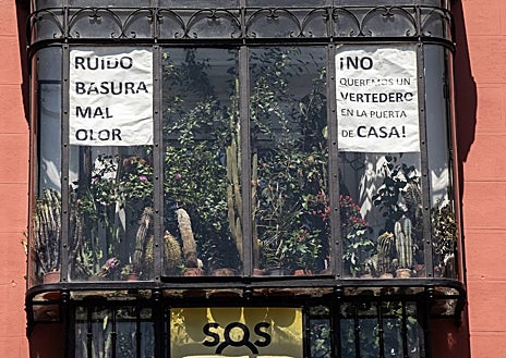Imagen secundaria 1 - Un indigente duerme entre colchones en Tirso de Molina; carteles de los vecinos denunciando el ruido y la basura; y letrero en la tienda que regenta el marido de Concha, también de uniformes