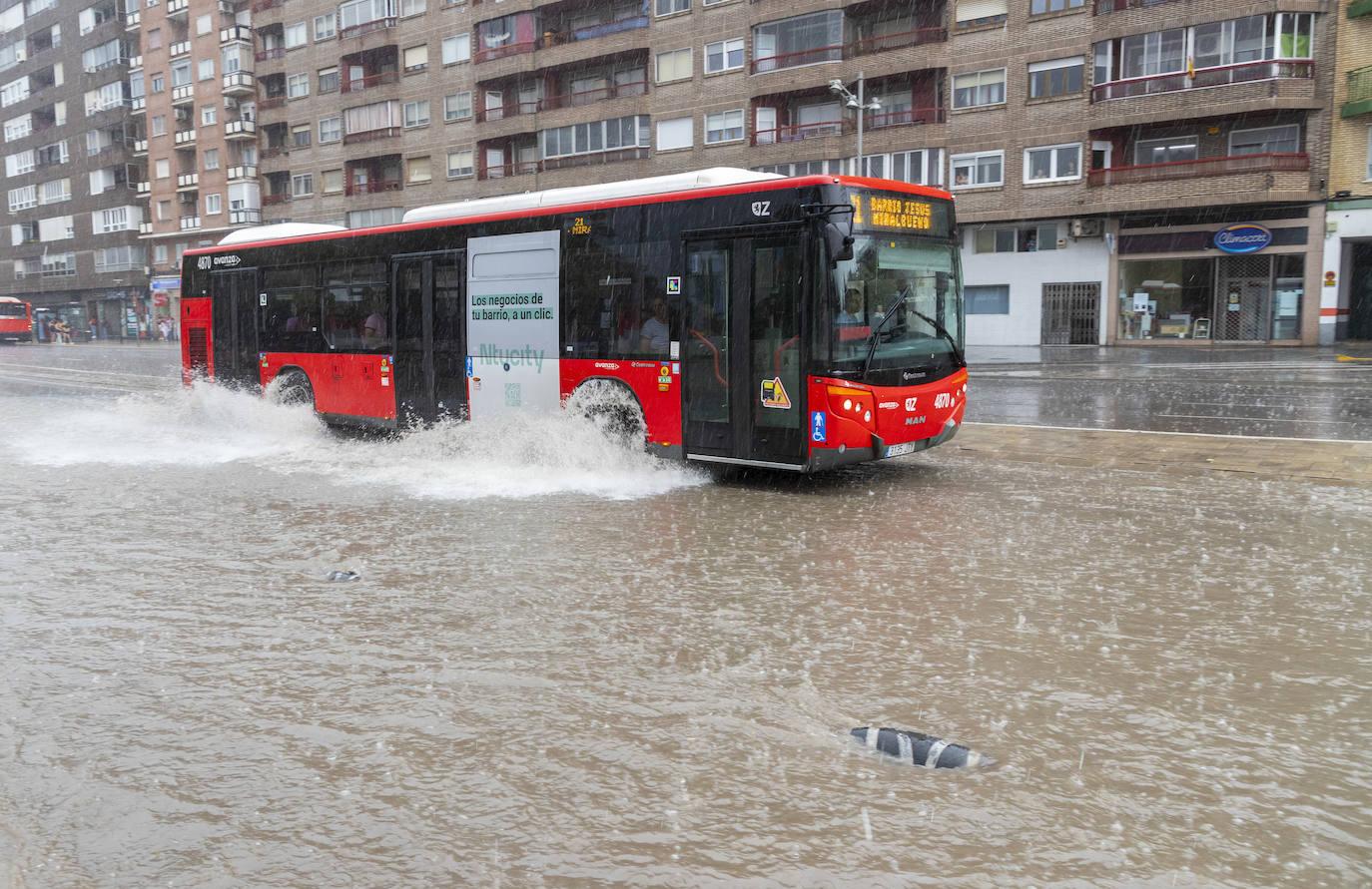 Un autobús público circula entre las calles anegadas.