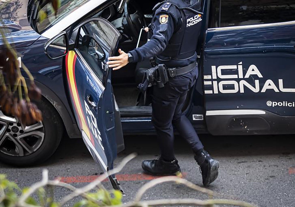 Agente de la Policía Nacional subiendo a un vehículo policial