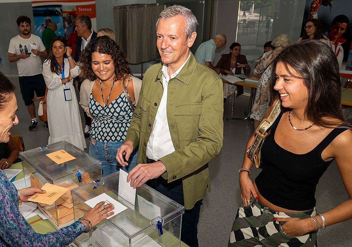 El presidente del PP gallego, Alfonso Rueda, votando esta mañana en Pontevedra acompañado por sus hijas