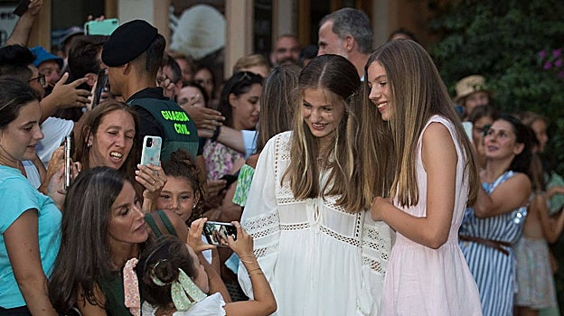 La Reina ayuda a una niña a hacer una foto a sus hijas en Valldemossa, Mallorca, hace un año