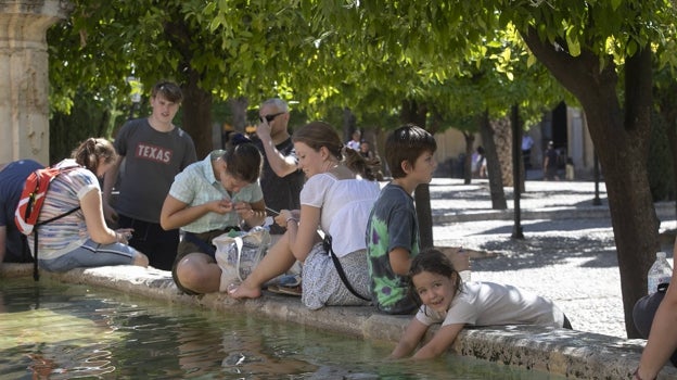 Turistas en la Fuente del Olivo del Patio de los Naranjos