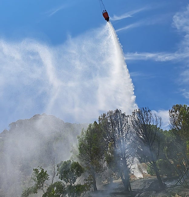Un helicóptero vierte agua sobre el pequeño fuego