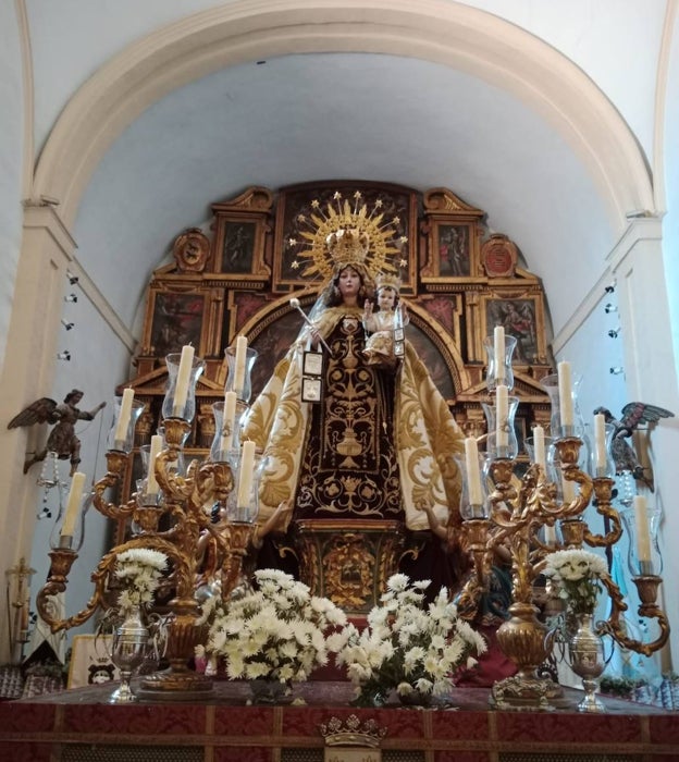 La Virgen del Carmen de Puerta Nueva, en su paso procesional, con el retablo de su iglesia al fondo