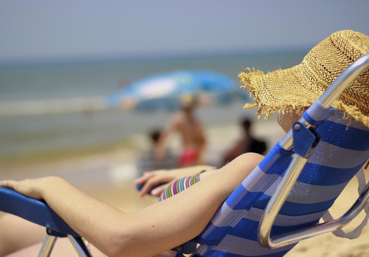 Imagen de archivo de una mujer echándose la siesta en la playa
