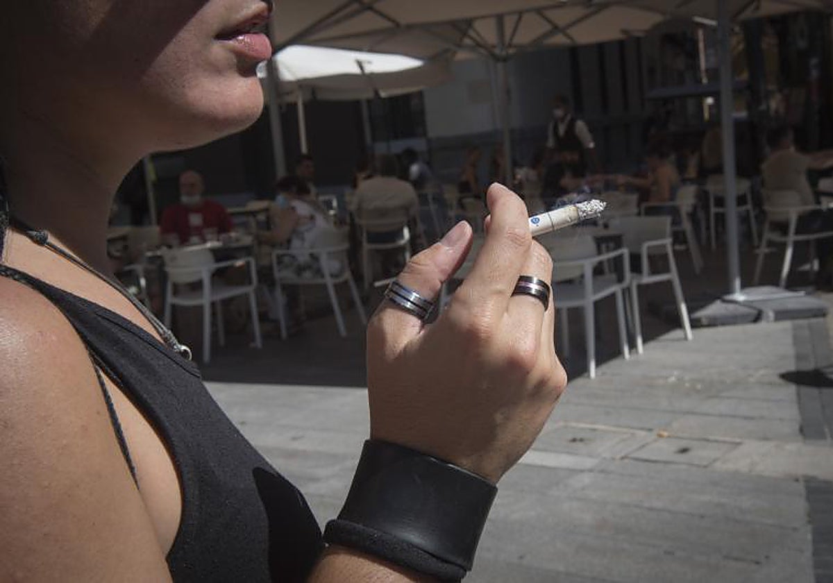 Imagen de archivo de una mujer fumando en la terraza de un bar