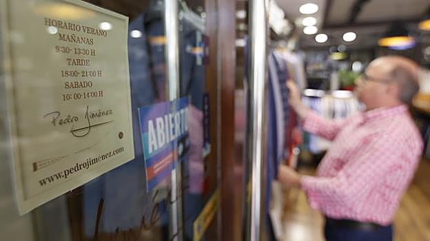 Cartel con el horario de verano de la tienda de Pedro JIménez, en la calle Góngora