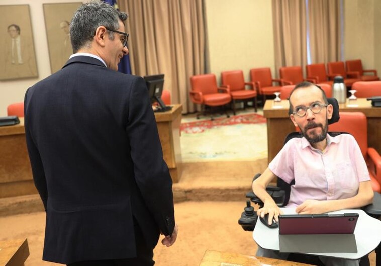 El portavoz de Unidas Podemos en el Congreso, Pablo Echenique, sonríe al ministro en funciones Félix Bolaños, que le dice algo en la Diputación Permanente