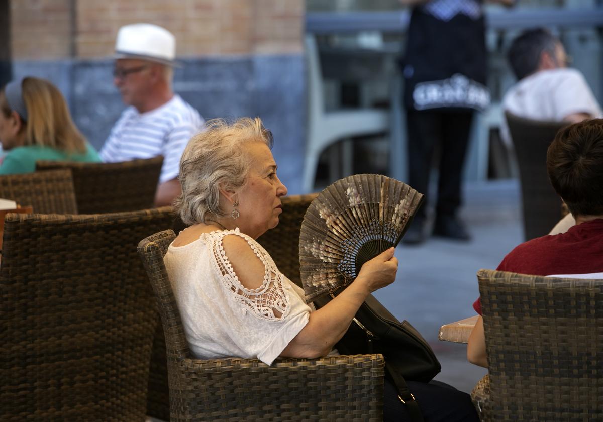 Una mujer se abanica en una terraza del Centro durante una ola de calor