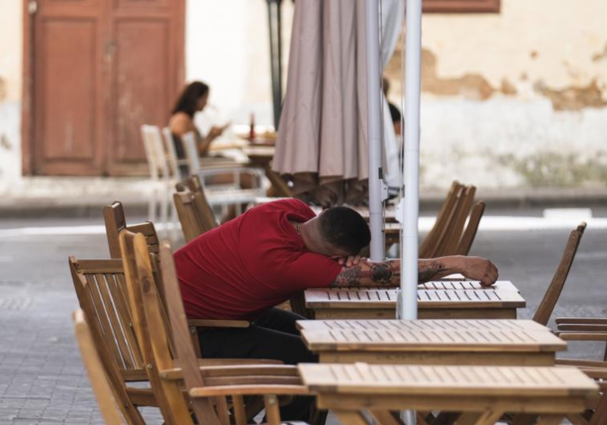 Un hombre descansa sobre la mesa de una terraza en La Laguna (Tenerife)