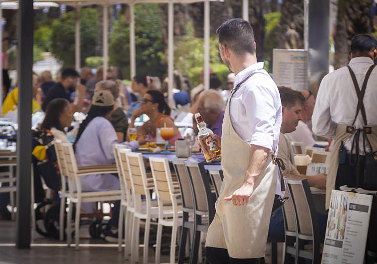 Imagen de archivo de un camarero atendiendo la terraza de un restaurante